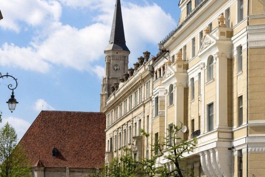 A building with a clock tower and a red roof. 1