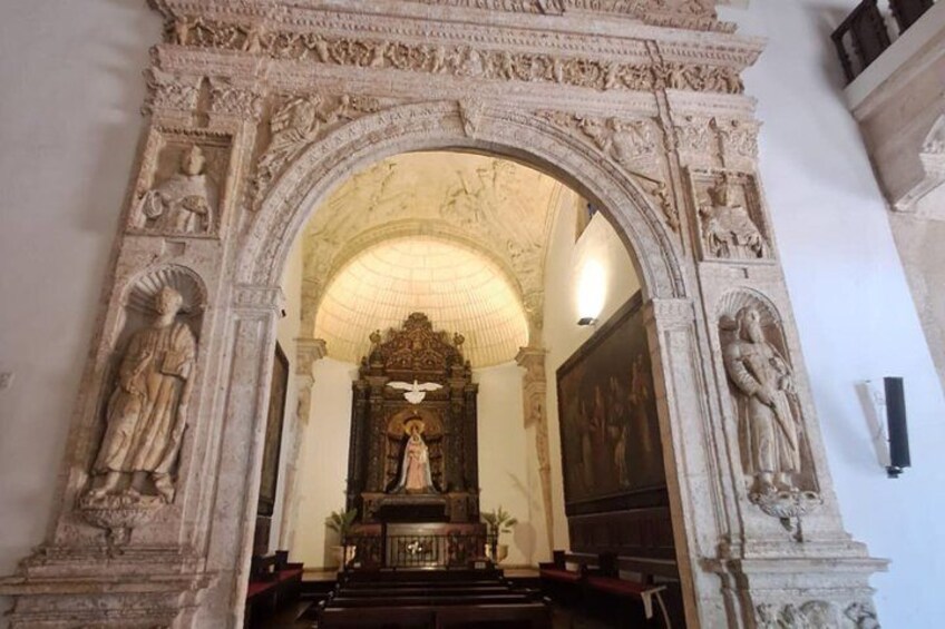 An ornate stone archway with religious statues and a central altar. 3