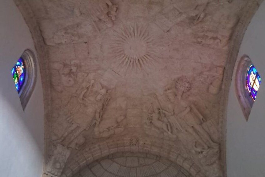 A ceiling with intricate carvings and two stained glass windows. 2