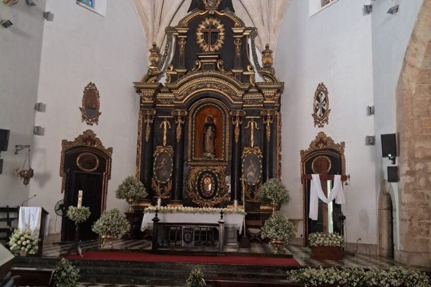 An ornate church altar with religious statues and floral decorations. 5