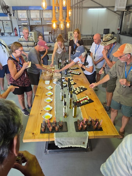 A group of people gathered around a long wooden table with food and drinks. 4