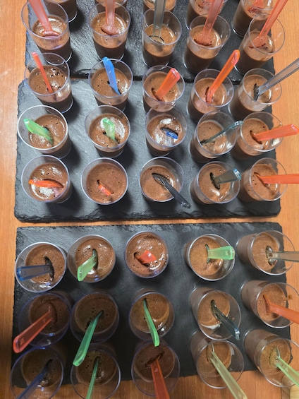 A tray of chocolate desserts with colorful plastic spoons. 2