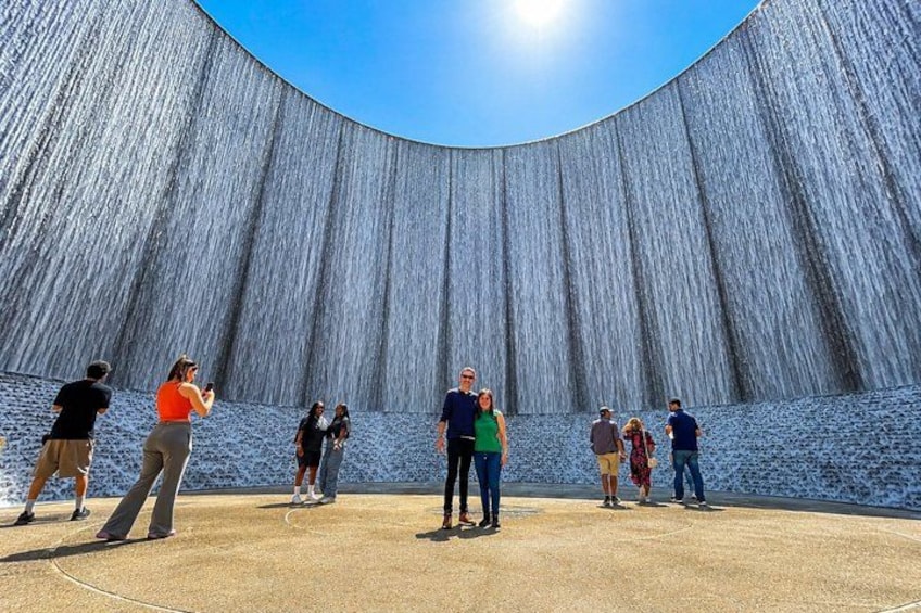 A large, curved wall with people standing in front of it. 1