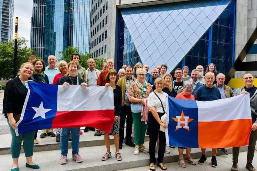 A group of people holding flags in front of a modern building. 2