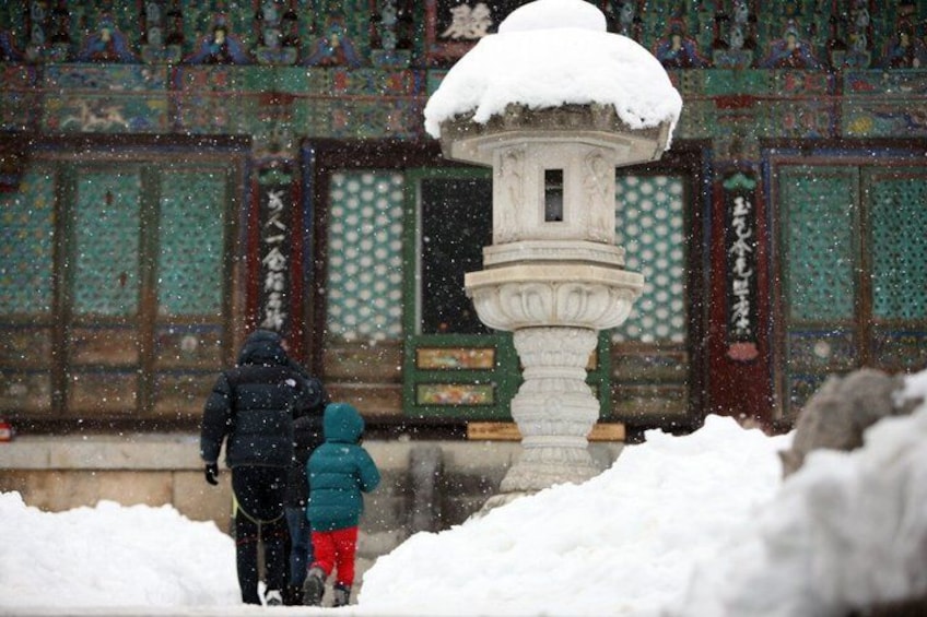 A snow-covered shrine with a traditional Japanese gate and a stone lantern. 5