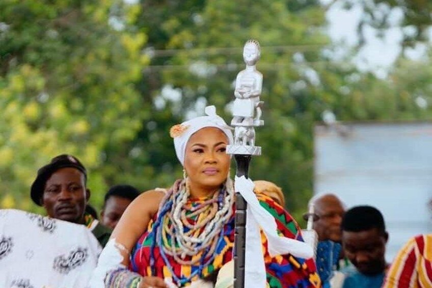 A person holding a ceremonial object, surrounded by others in traditional attire. 1