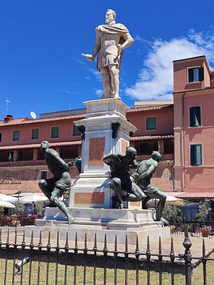A statue of a historical figure on a pedestal with three dynamic figures below. 3
