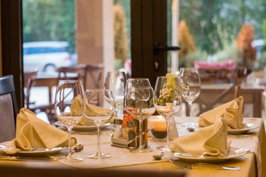 A restaurant table set with wine glasses, plates, and napkins. 2