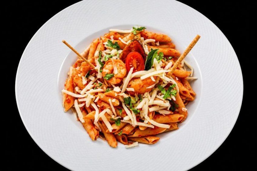 A plate of pasta with shrimp, tomatoes, and cheese. 4
