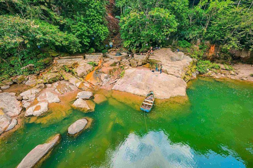 A river with clear water, rocks, and a small boat anchored near the shore. 3