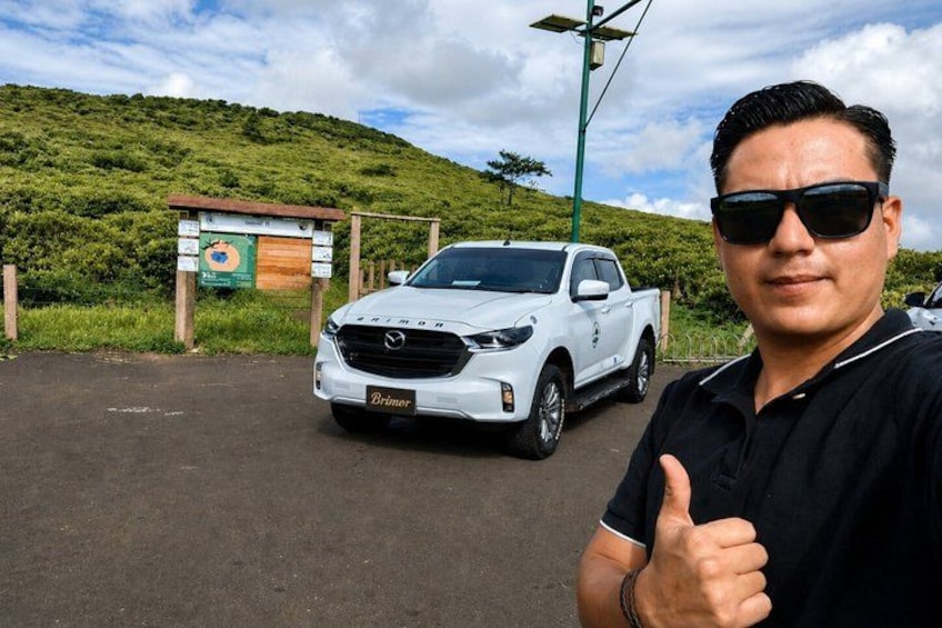 A white pickup truck parked on a road with a hilly landscape in the background. 3