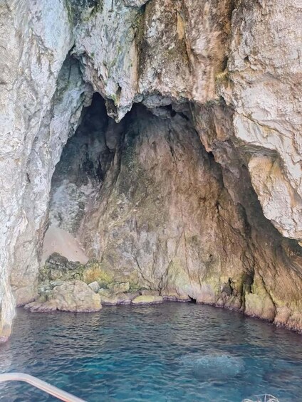 A natural cave entrance with water at the base. 2