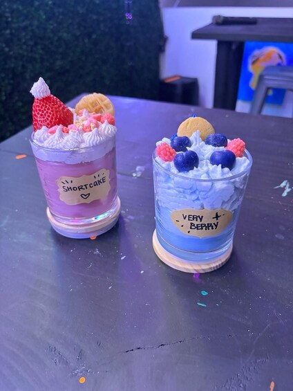 Two colorful drinks with toppings on a table. 2