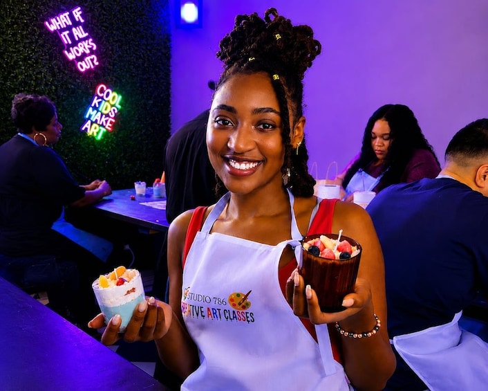 A person holding a dessert with a neon sign in the background. 5