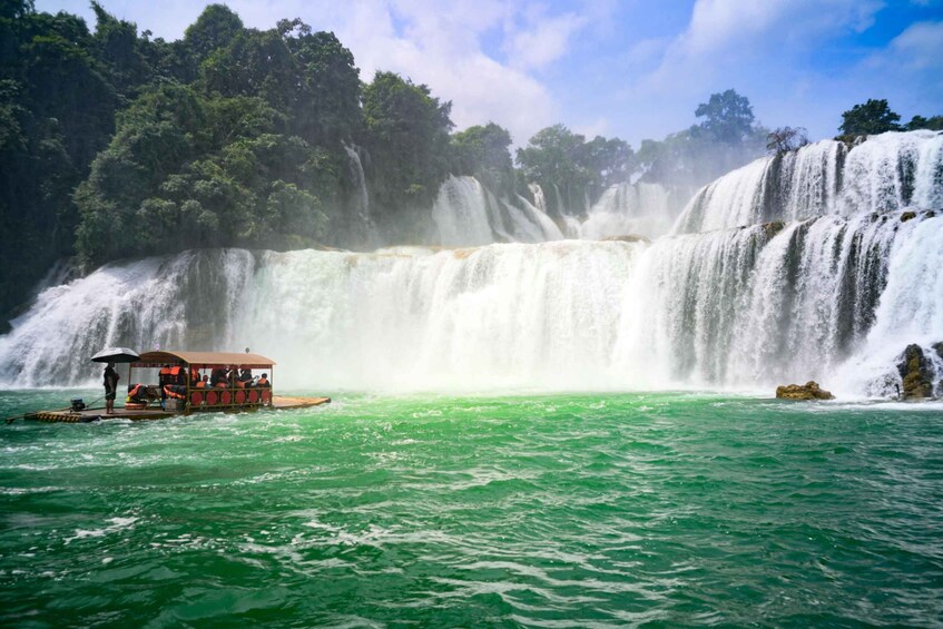 A boat with passengers enjoying a waterfall view. 1