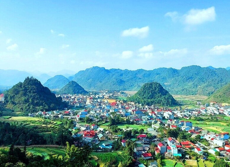 A mountainous landscape with a town nestled among green fields and terraced hills. 3