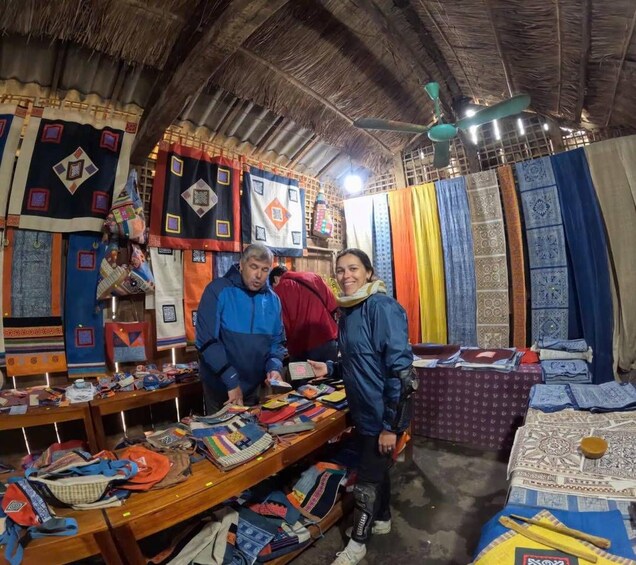 A traditional market with patterned textiles and rugs displayed on tables. 4