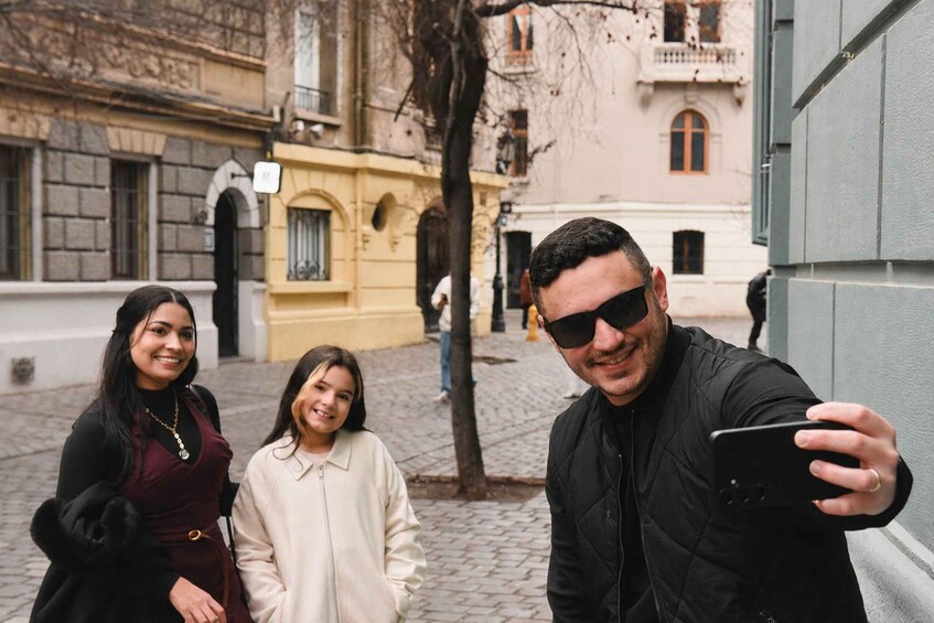 Un gruppo di persone si fanno un selfie in una strada acciottolata con edifici storici. 3