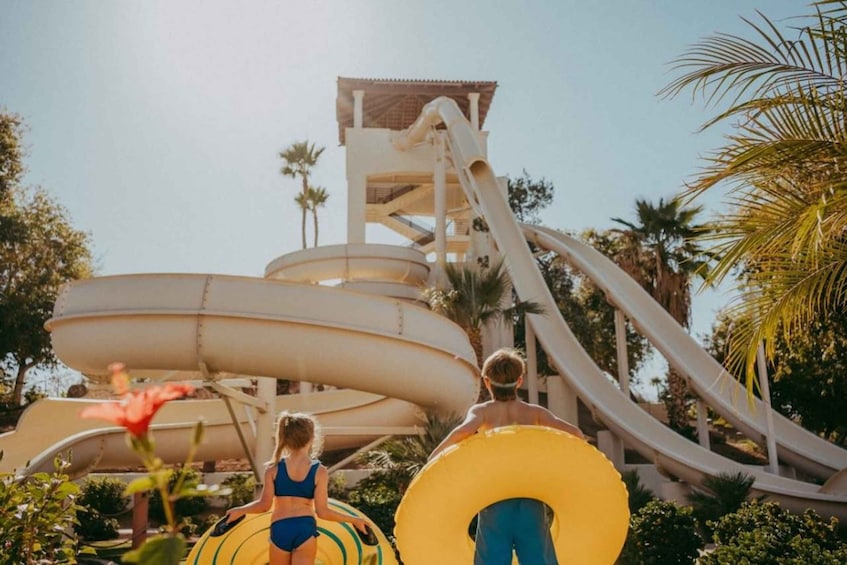 A water park with multiple water slides and a large yellow inflatable tube. 5