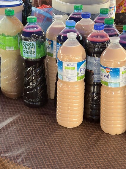 A variety of bottled beverages with labels, arranged on a patterned surface. 2