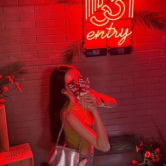 A person holding a shoe with a neon sign in the background. 3