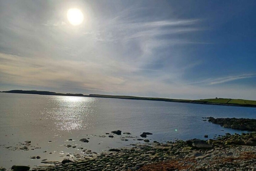 A calm body of water with a clear sky and a distant shoreline. 2