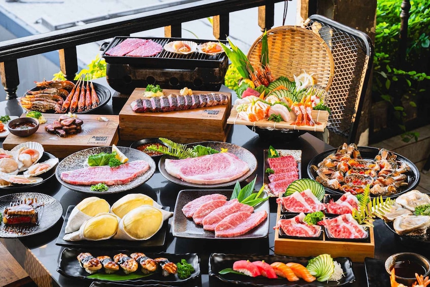 A variety of seafood and meats, including grilled items and sushi, arranged on a table outdoors. 1