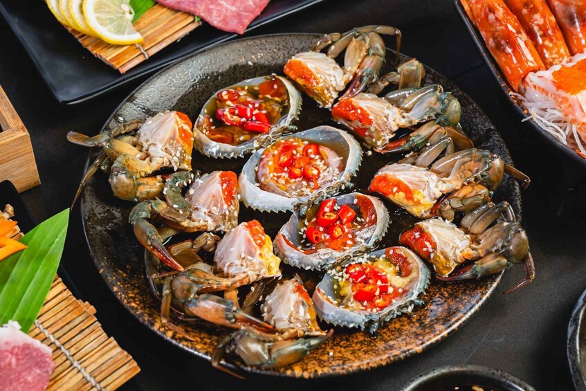A plate of cooked crabs garnished with red chili and sesame seeds. 5