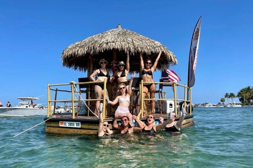 A boat with a thatched roof and passengers enjoying the water. 1