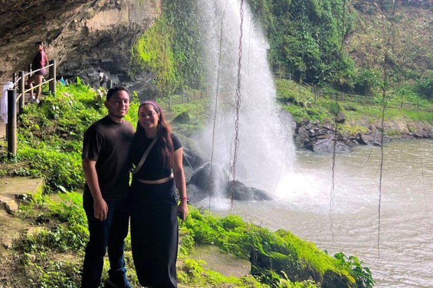 A waterfall, a river, and a person standing on a path. 1