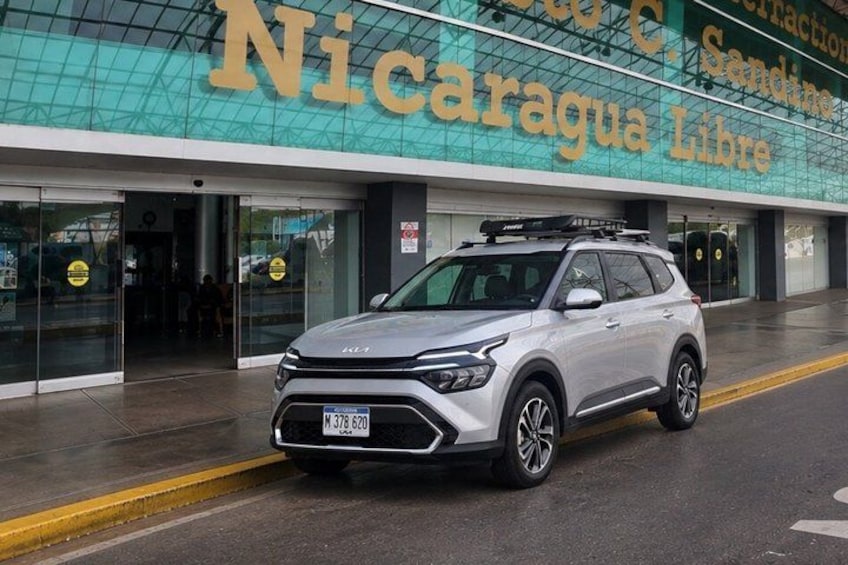 A white SUV parked in front of a building with a sign that reads 'Nicaragua Libre.' 1