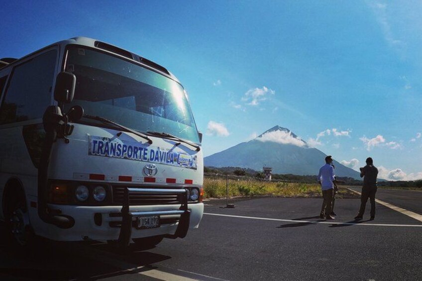 A bus with 'TRANSPORTE DAVILAN' written on it, parked on a road with a mountain in the background. 2