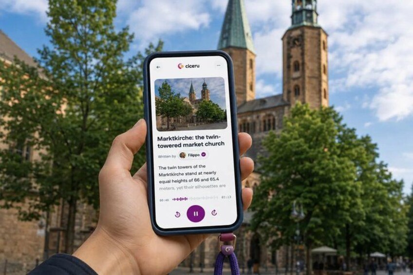 A hand holding a smartphone displaying a photo of a historic church with twin towers. 1