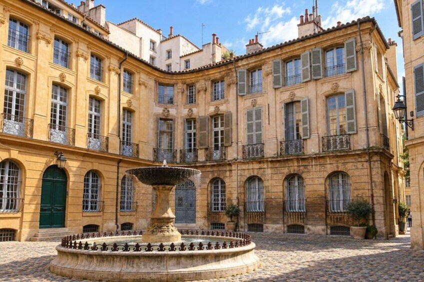 A historic building with a courtyard, a fountain, and a cobblestone ground. 3
