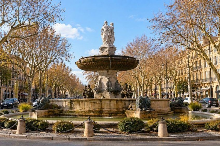 A fountain with statues, surrounded by trees and buildings. 1