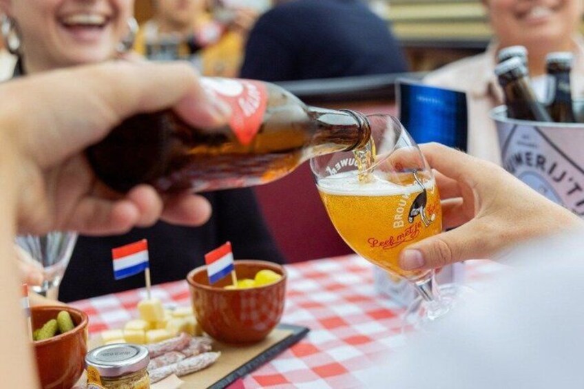 A person pouring beer into a glass with a flag design. 4