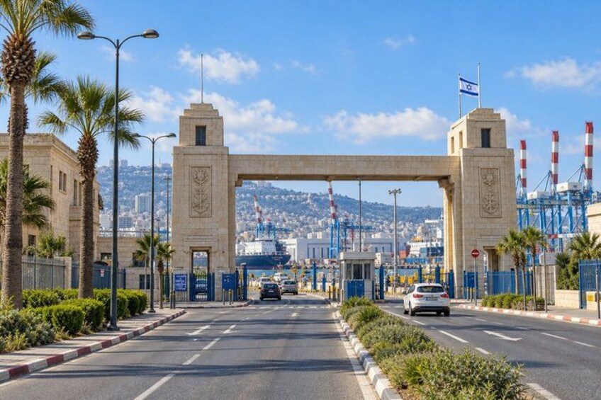 A coastal city entrance with a large archway, palm trees, and a clear blue sky. 5