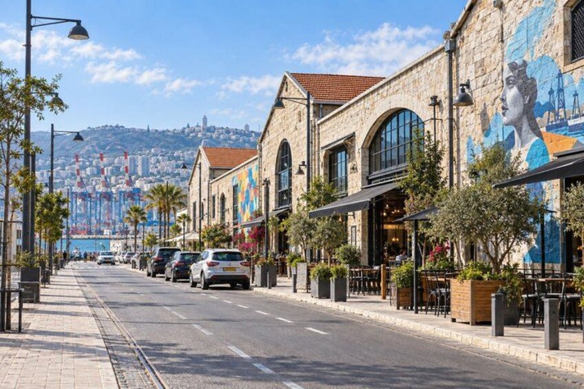 A street with buildings, cars, and a mural. 4