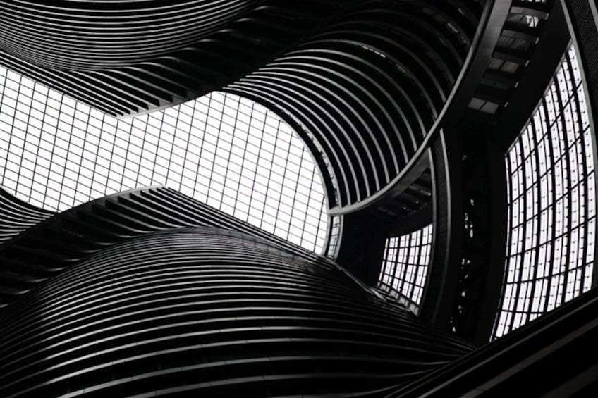 A modern architectural structure with curved lines and a grid-like pattern. 4