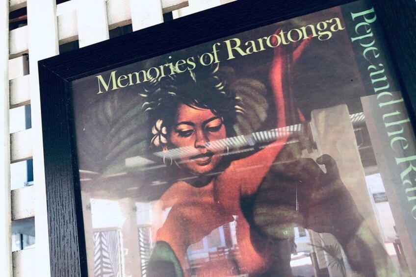 A framed artwork with a person playing a flute, titled 'Memories of Rarotonga.' 1