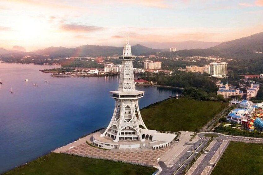A tower with a spiral staircase, surrounded by a waterfront and buildings in the background. 2