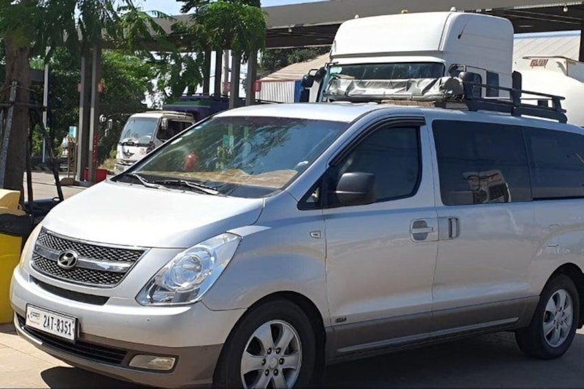 A silver minivan parked on a street with a trailer attached. 5