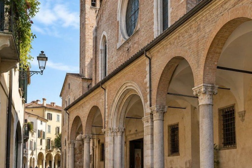 A historic building with arched walkways and columns. 5