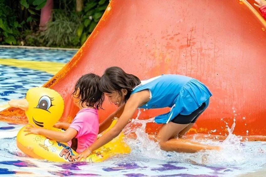 Two children playing in a water slide with a yellow inflatable duck. 2