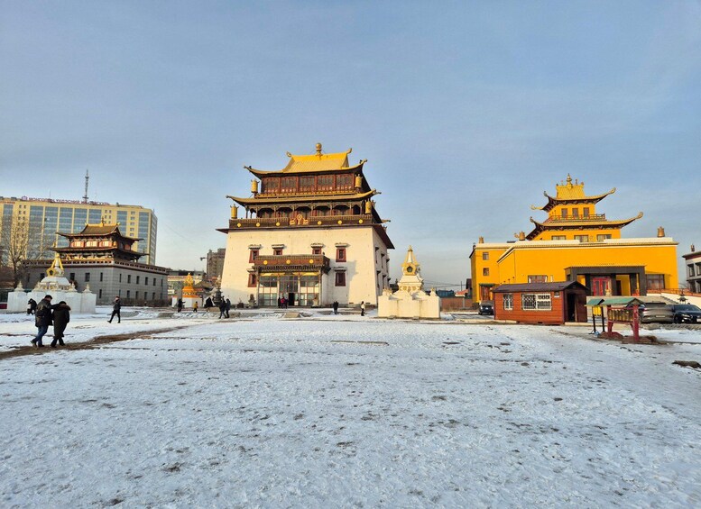 Un edificio tradicional con techo dorado y suelo cubierto de nieve. 5