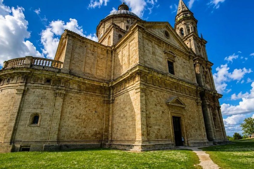 A large, historic building with a dome and bell tower, surrounded by a grassy area. 5