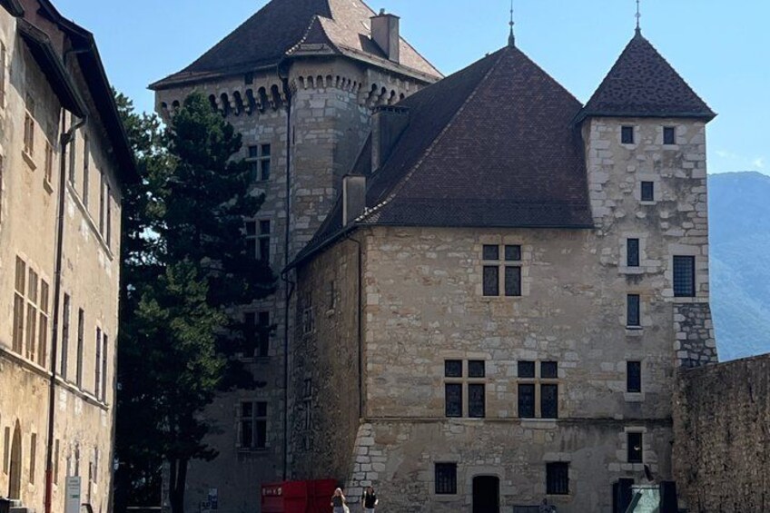 A historic stone building with a tower and a steeply pitched roof. 2