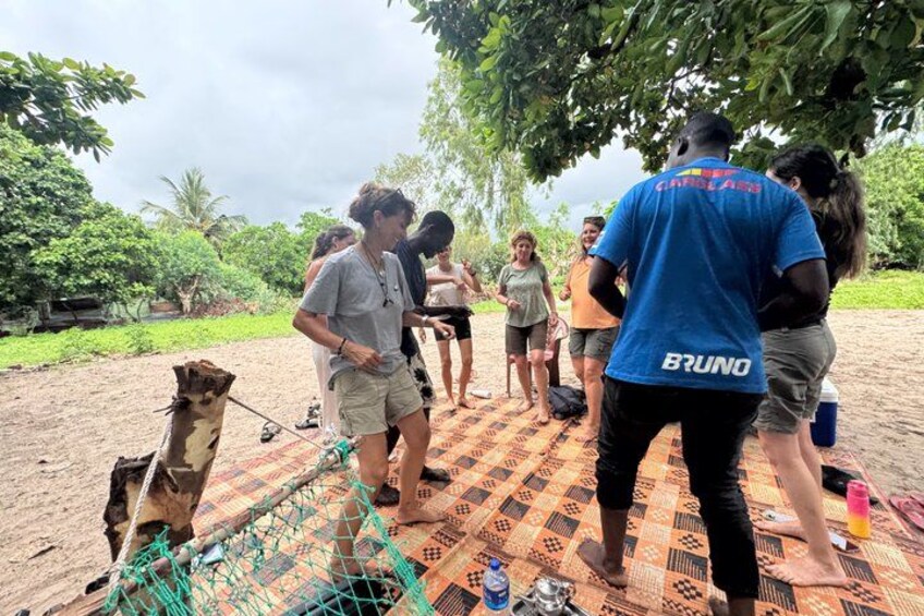 A group of people outdoors on a patterned mat, a camel, and a person in a blue shirt with 'BRUNO' on the back. 4