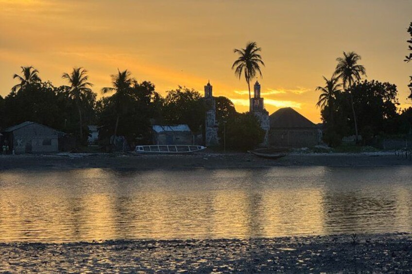 A sunset over a calm river with buildings and palm trees. 3
