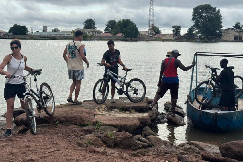 People near a body of water with bicycles and a boat. 2